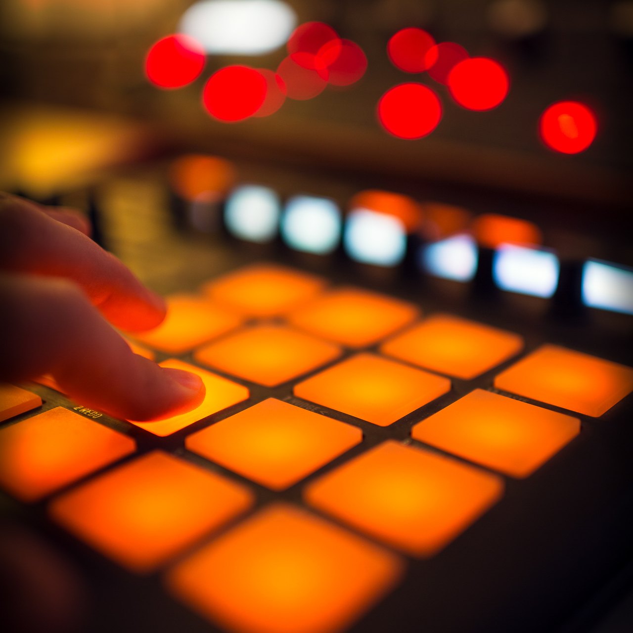 A finger on lit drum pads